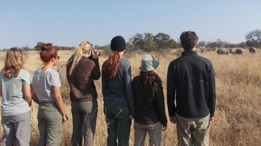 Earthwatch volunteers observe rhinos in the distance (C) Lynne MacTavish